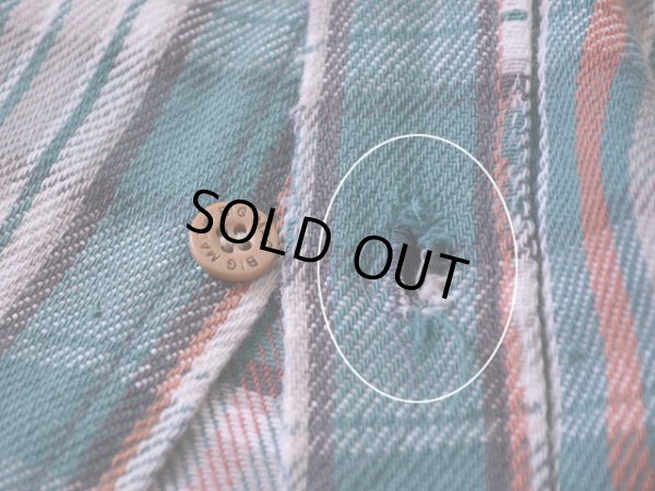 一番下のボタンホールにホツレ。