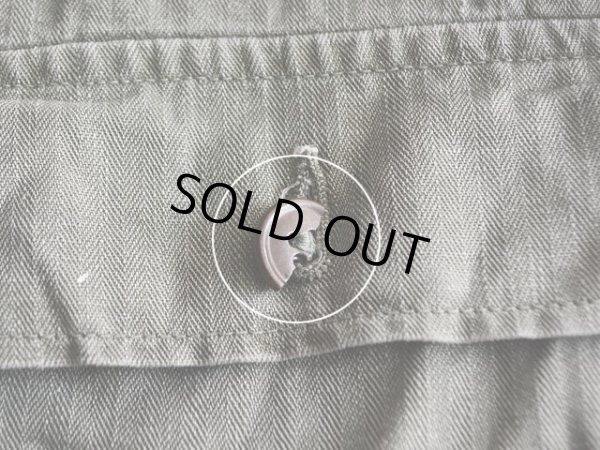 右胸ポケットフラップボタンに欠け。